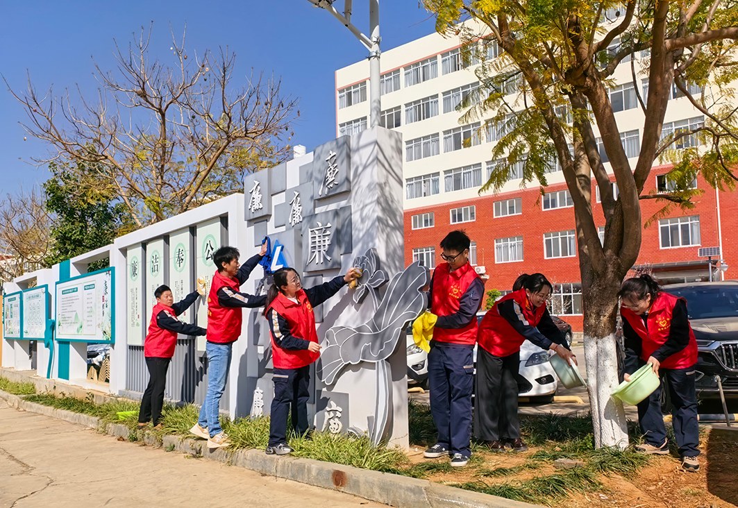 图为凉山矿业志愿者擦拭廉洁长廊。邹港 摄